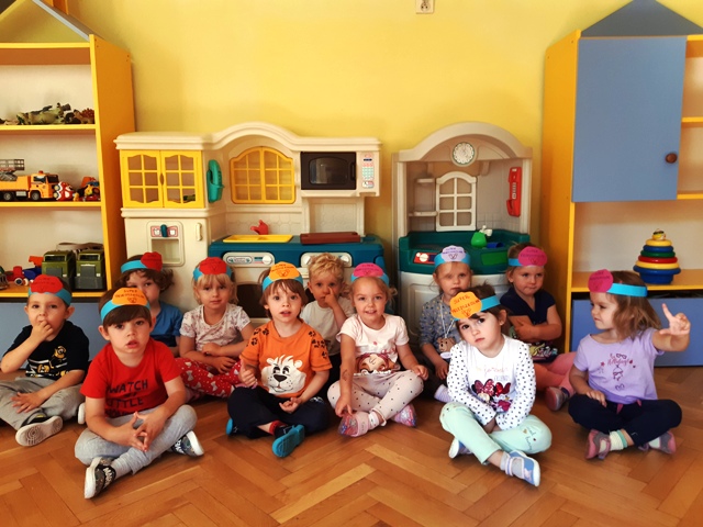 grupa 3 - letnich dzieci w sali przedszkolnej z opaskami na głowach z napisem "Super przedszkolak"