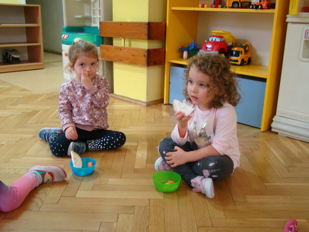 dziewczynki wąchają kawałki selera - dzieci poznają zapachy warzyw