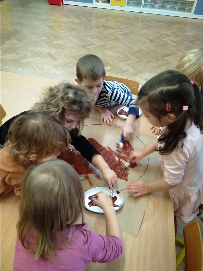 Dzieci malują farbami części ciała misia