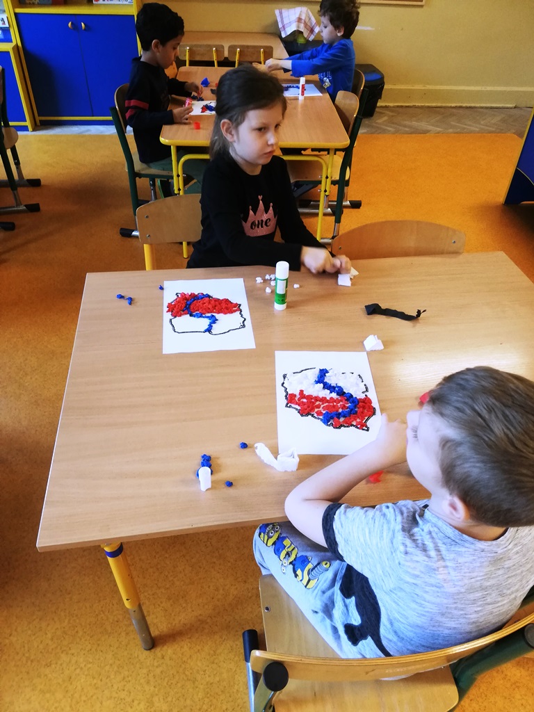  Dzieci wyklejają kontur Polski kuleczkami z bibuły