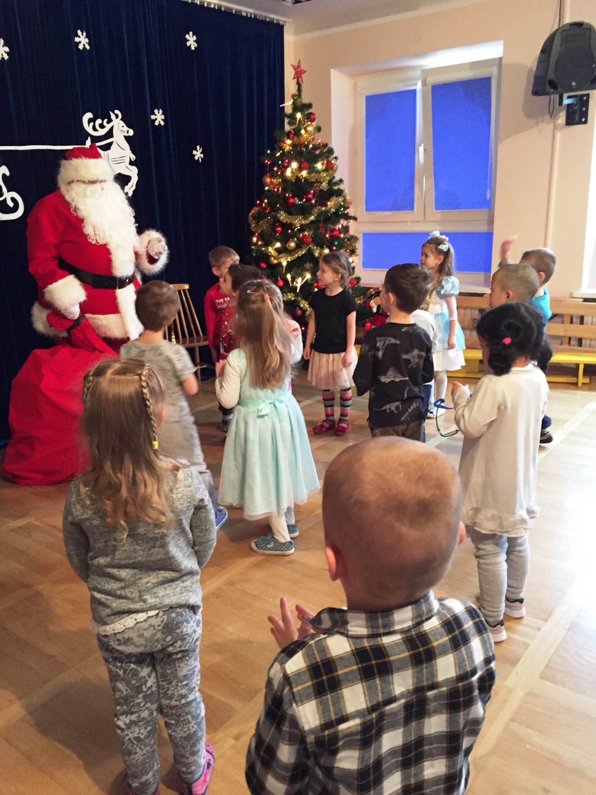 dzieci stoją przed Mikołajem