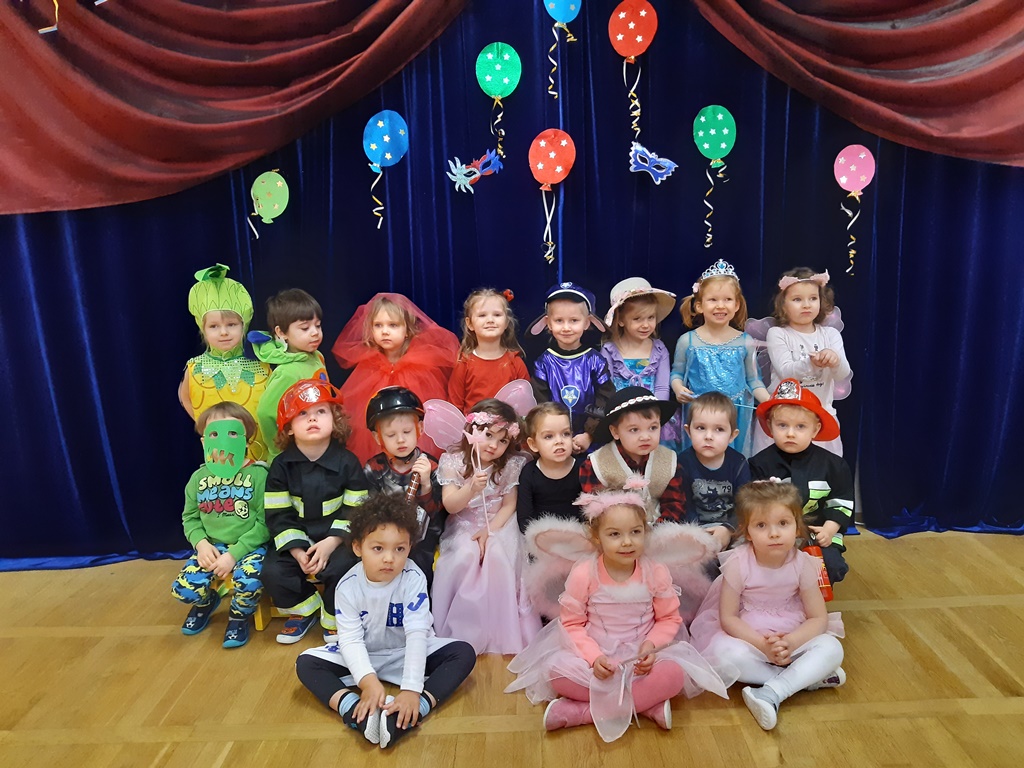 zdjęcie grupowe dzieci w strojach karnawałowych na tle kolorowych balonów