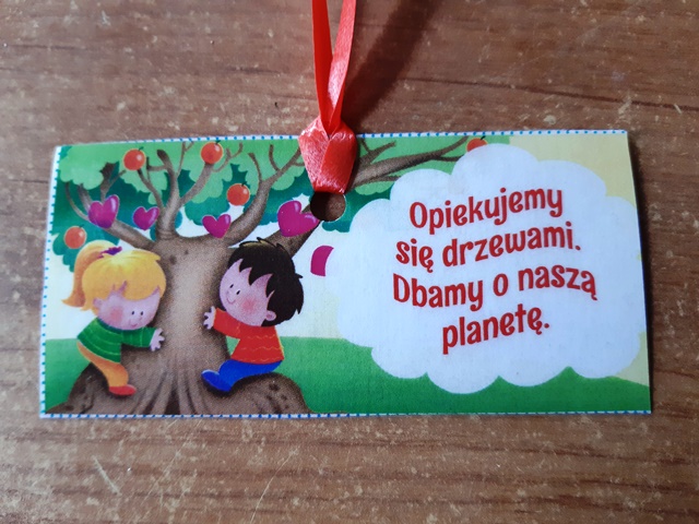 odznaka pamiątkowa z okazji Dnia Drzewa napisem "Opiekujemy się drzewami . Dbamy o naszą    planetę"