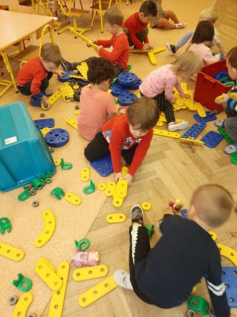 dzieci bawią się na podłodze klockami