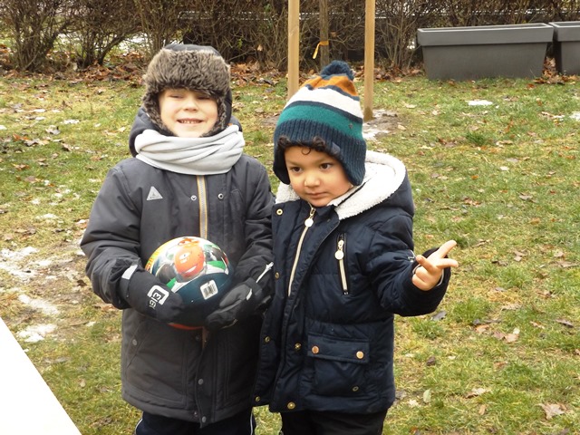chłopcy w ogrodzie z piłką
